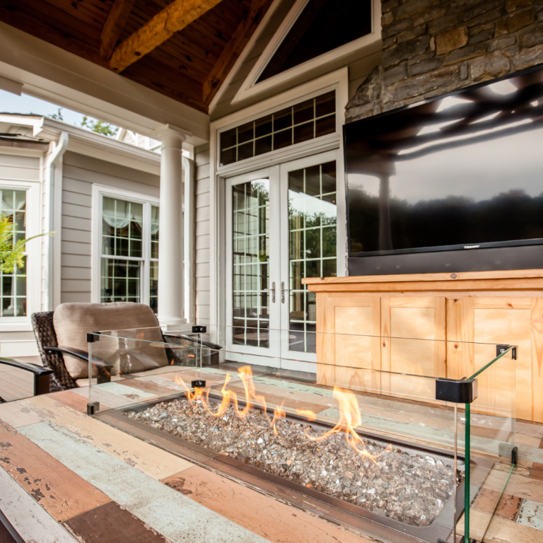 Flagstone patio with a circular stone fire pit and Adirondack chairs in a Lexington backyard at dusk.