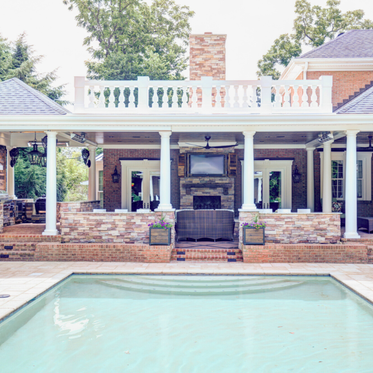 Outdoor kitchen and lounge area with TV and fireplace